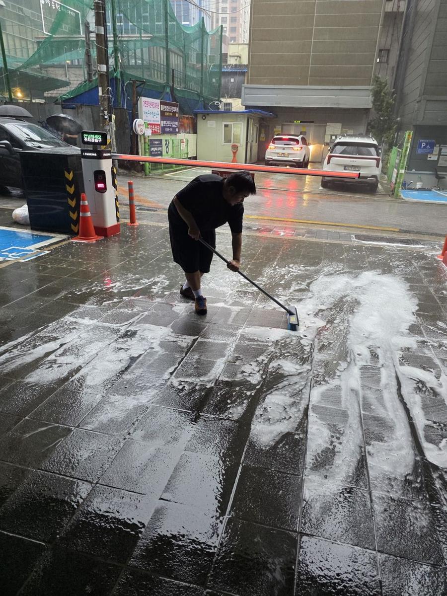 건물 앞 바닥을 세척하는 JNR 직원