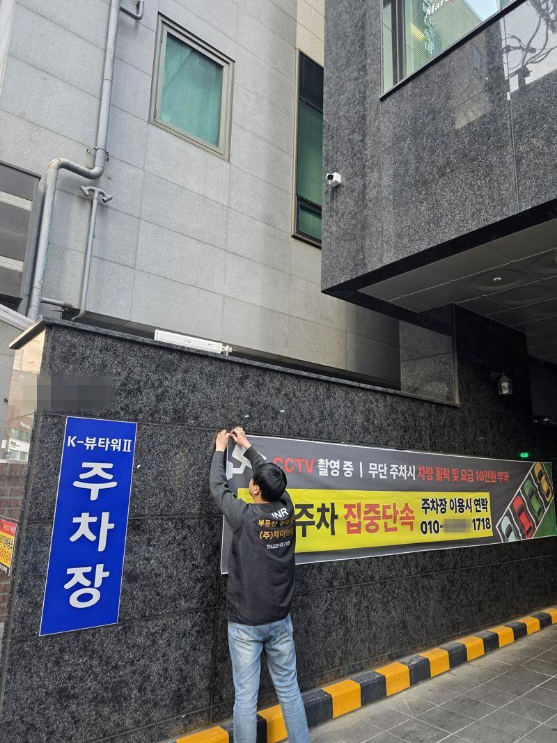 주차 안내 현수막을 설치하는 JNR 직원