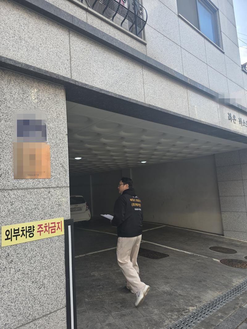 건물 전면과 주차구역을 확인하는 JNR 직원